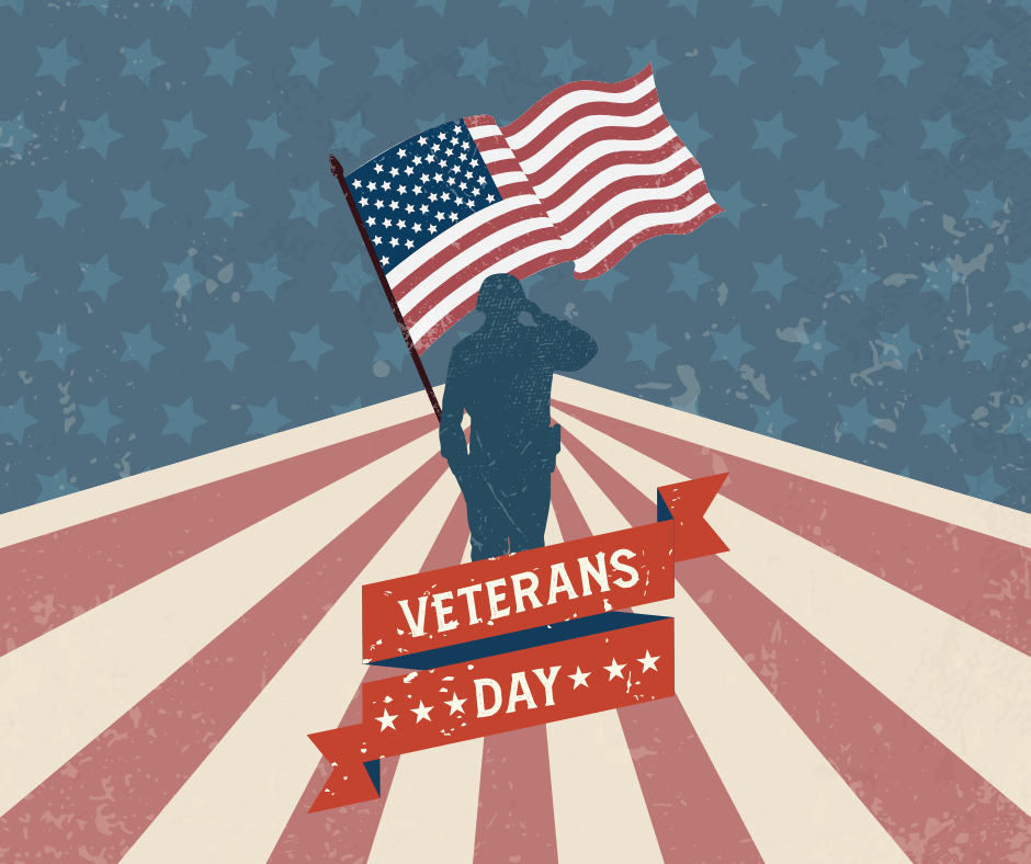 Outline of soldier saluting and holding American flag standing in from=nt of a background with blue stars and red and white stripes. Text reads Veterans day